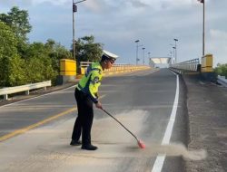 Personil Satlantas Polres Bintan Bersihkan Tumpahan Pasir di Jalan Lintas Barat